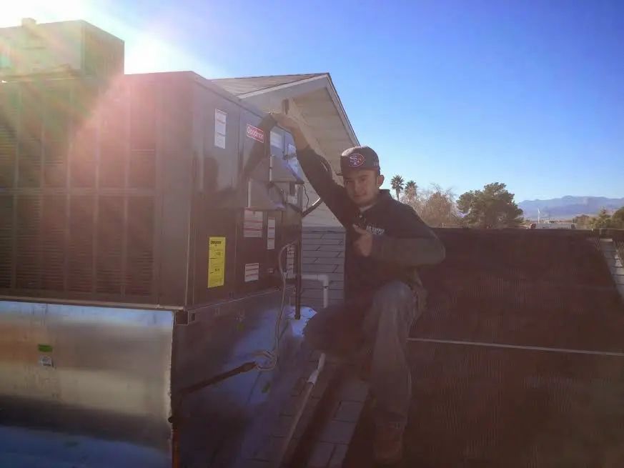 HVAC technician performing AC Tune-Up on a rooftop unit in La Grange